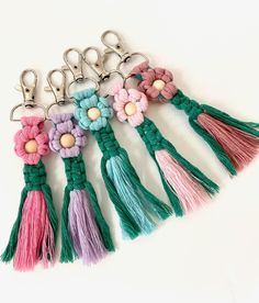 six key chains with flowers and tassels on them