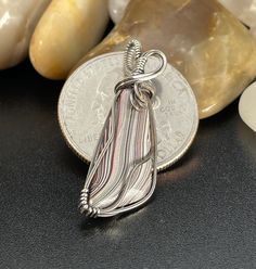 "This is a dainty man made stone wrapped in sterling silver. The story behind the material, as I know it, is it is dried paint from car manufacturers. This has been cut in shaped into a pendant. Neat!  Comes with an 18\" fine silver chain." Artisan Silver-plated Nickel-free Jewelry, Nickel-free Unique Silver-plated Jewelry, Artisan Nickel-free Jewelry In Silver Plated Wire, White Sterling Silver Wire Wrapped Jewelry, Silver Wire Wrapped Round Pendant Jewelry, Silver Wire Wrapped Jewelry With Round Pendant, Silver Wire Wrapped Pendant Jewelry, Unique Silver Wire Wrapped Jewelry, Artisan Silver Jewelry With Cabochon