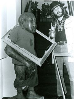 two men standing next to each other holding frames