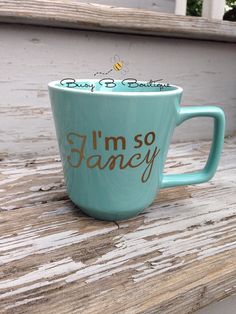 a blue coffee cup with the words i'm so fancy written in gold on it