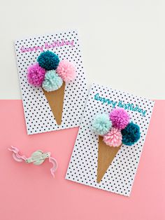 two ice cream cones decorated with pom - poms