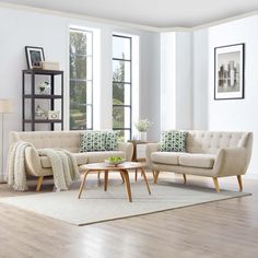 a living room filled with furniture and a fire place in front of two windows on top of a hard wood floor