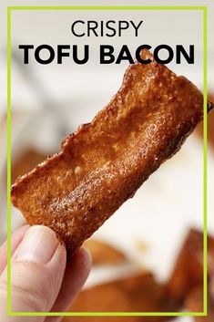 crispy tofu bacon on a stick is being held in front of the camera