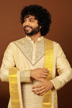 Gold pattu kurta featuring zari and cutdana hand embroidery on the neckline and sleeve hem. Paired with a dhoti pant and a kanduva. - Aza Fashions Transitional Cotton Silk Sherwani With Cutdana, Ceremonial Cotton Silk Bandhgala With Zari Work, Ceremonial Cotton Silk Bandhgala For Festivals, Designer Tussar Silk Gold Kurta, Ceremonial Tussar Silk Kurta For Transitional Season, Designer Gold Tussar Silk Kurta, Zari Work Cotton Silk Bandhgala For Festivals, Diwali Tussar Silk Sherwani With Resham Embroidery, Transitional Ceremonial Tussar Silk Kurta