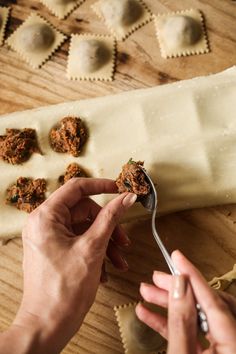 a person holding a fork with some food on top of it next to ravioli