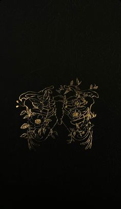 a black and gold book cover with an intricate design on the front, featuring leaves and flowers