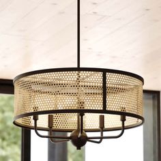 a chandelier hanging from the ceiling in front of a window with trees outside