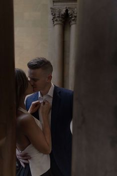 a man in a suit and tie standing next to a woman