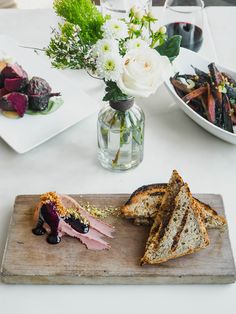 there are three pieces of bread on the table with flowers in vases behind it