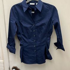 This Navy Blue Dress Shirt Has Buttons Down The Front And Long Sleeves That Roll Up. The Sides Are Slightly Cinched In For A. Better Fit. This Is Brand New With Tags.. Measurements 17’ Ptp Length 25’. Blue Slim Fit Top For Office Wear, Navy Collared Office Top, Navy Workwear Tops With Button Closure, Navy Fitted Office Shirt, Navy Button Closure Top For Work, Navy Fitted Shirt For Spring, Navy Collared Top For Office, Fitted Navy Shirt For Spring, Fitted Navy Shirt For Office