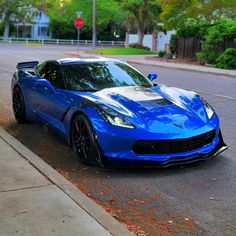 a blue sports car parked on the side of the road