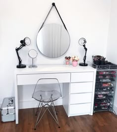 a white desk with a mirror, chair and other items on it in a room