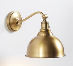 an antique brass wall light on a white background with the bulb turned off and one arm extended