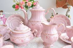 a pink tea set is sitting on a table