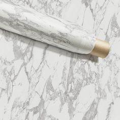 a white marble counter top with a rolled up roll of toilet paper next to it