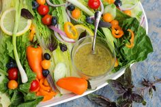 a platter filled with lettuce, carrots and other vegetables