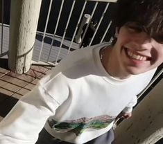 a young man is smiling while eating food