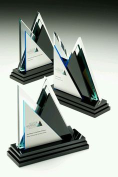 three glass awards are stacked on top of each other in the shape of pyramids