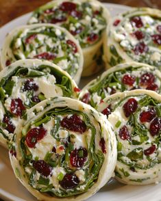 several cranberry spinach wraps on a white plate