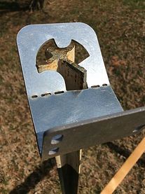 a metal object sitting on top of a piece of wood in the middle of a field