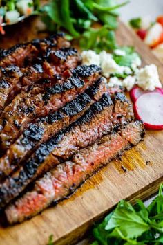 the steak is prepared and ready to be cooked on the grill, with fresh herbs around it