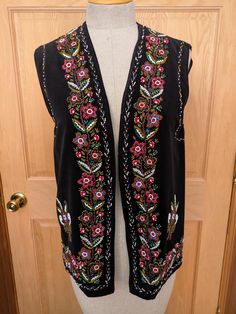 Beautiful black velveteen beaded vest from the 60's in the classic traditional folk design of Romania.  The beaded designs are very colorful and intricate on the front and back, and the vest is fully lined in black rayon.  There is a 1/2" section of beading missing from the left back armhole, but otherwise the vest is in excellent condition.  These vests are Unisex and the measurements are approx: 15" across the shoulders 37" armhole to armhole when closed 38" around the bottom when closed 26" overall length Bohemian Black Embroidered Vest, Beaded Vest, Beaded Designs, Folk Design, Vest Outfits, Womens Vest, Romania, Beading, 1960s