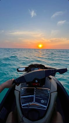 the sun is setting over the ocean from a boat