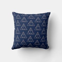 a harry potter pattern on a blue pillow with the deathly hall symbol in white