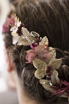 a woman with flowers in her hair is wearing a flowery headpiece that has leaves and beads on it