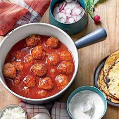 meatballs in tomato sauce with pita bread and sour cream on the side, ready to be eaten