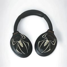 a pair of black headphones with white spider - man designs