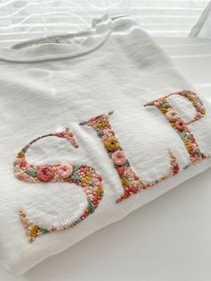 a white t - shirt with the word child written in floral letters and flowers on it