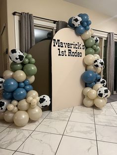 balloons are arranged in the shape of cows and soccer balls, along with a sign that says merrick's 1st rodeo