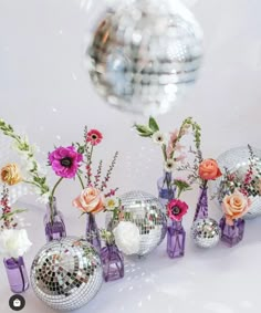 several vases filled with flowers and disco balls