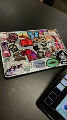 a laptop computer sitting on top of a table covered in stickers