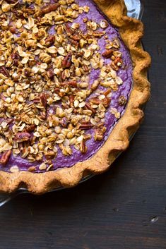 a purple sweet potato pie with chopped nuts and crumbled pecans on top