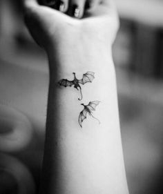 a black and white photo of a woman's wrist tattoo