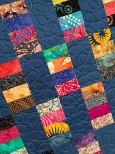 a blue quilt with many different colored squares on it