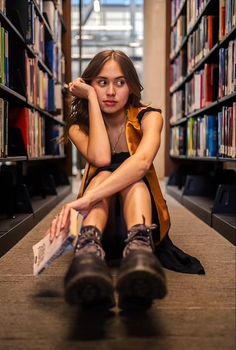 a woman sitting on the floor in a library