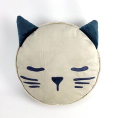 a white cat pillow with blue eyes and ears