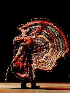 a woman is dancing with an elaborate costume