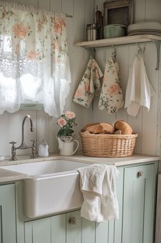 a white sink sitting under a window next to a basket filled with bread on top of a counter