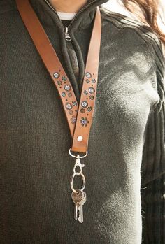 a woman wearing a brown leather lanyard with keys attached to it's neck