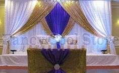 a bed with purple and gold drapes on it