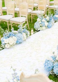 the aisle is decorated with blue and white flowers