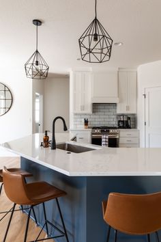 a kitchen with two bar stools next to an island