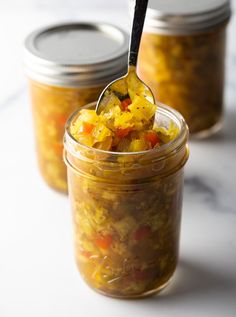 two jars filled with food sitting on top of a white counter next to each other