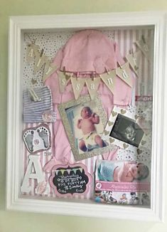 a baby's first birthday display in a white frame with pink and gold decorations