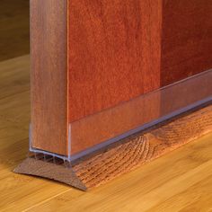 a close up view of a wooden floor with a metal strip on the bottom edge