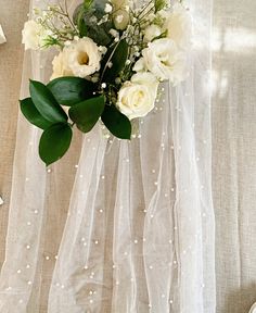 a bouquet of flowers sitting on top of a bed next to a white wallpaper